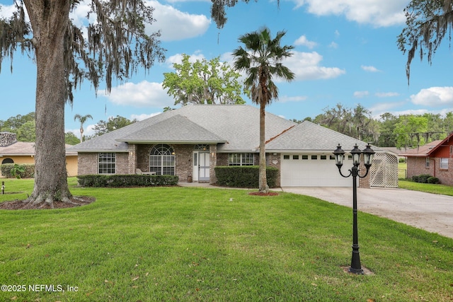 ranch-style home featuring concrete driveway, a front yard, a shingled roof, and a garage