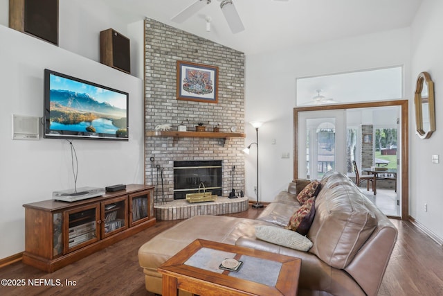 living area with wood finished floors, a brick fireplace, baseboards, a ceiling fan, and lofted ceiling