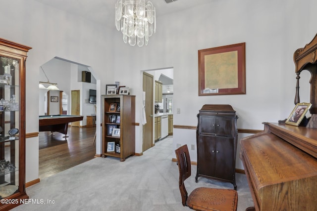 office featuring a high ceiling, an inviting chandelier, pool table, baseboards, and light colored carpet