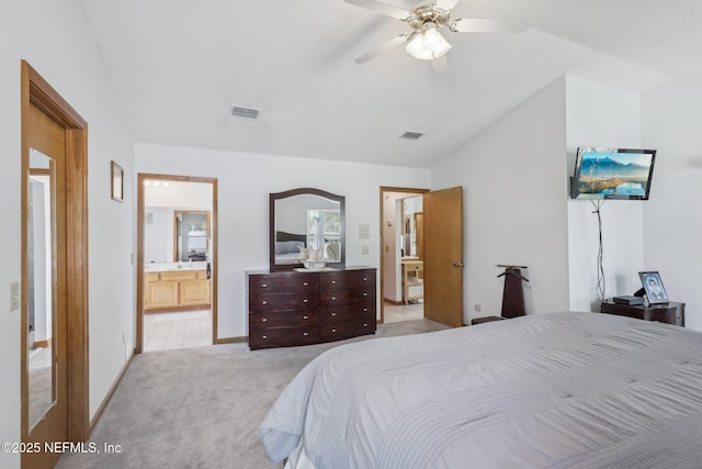 bedroom featuring connected bathroom, light colored carpet, baseboards, visible vents, and lofted ceiling