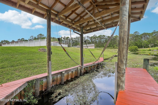 view of dock featuring a lawn and a water view