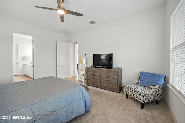 carpeted bedroom with ceiling fan, ensuite bath, and visible vents