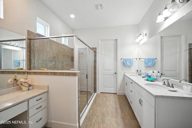 bathroom with double vanity, a sink, baseboards, and a shower stall