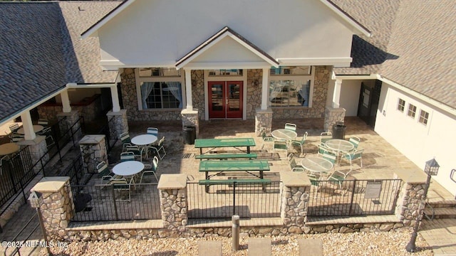 15717 Basil Creek Ct, Jacksonville, FL 32218 - back of house with french doors, stone siding, a patio, and stucco siding