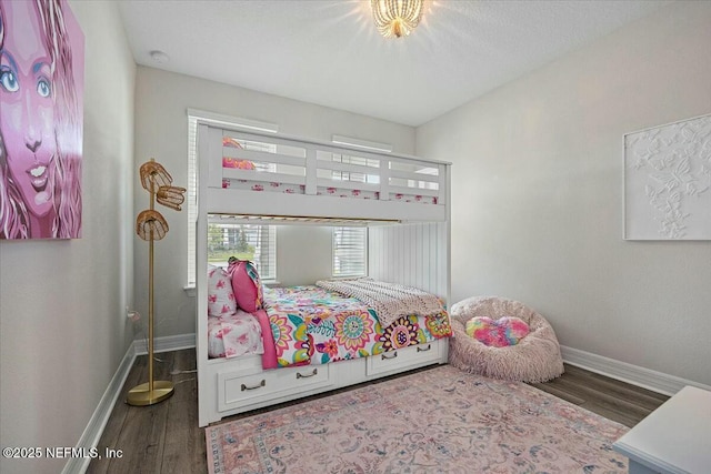bedroom with baseboards and wood finished floors