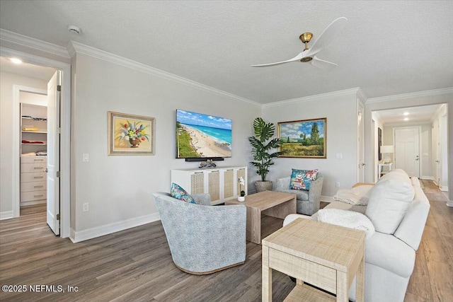 living room with ornamental molding, a ceiling fan, wood finished floors, and baseboards