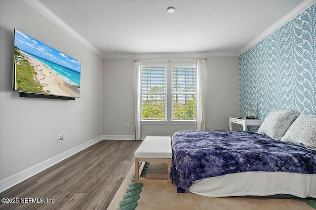 bedroom featuring a textured ceiling, wood finished floors, crown molding, and baseboards
