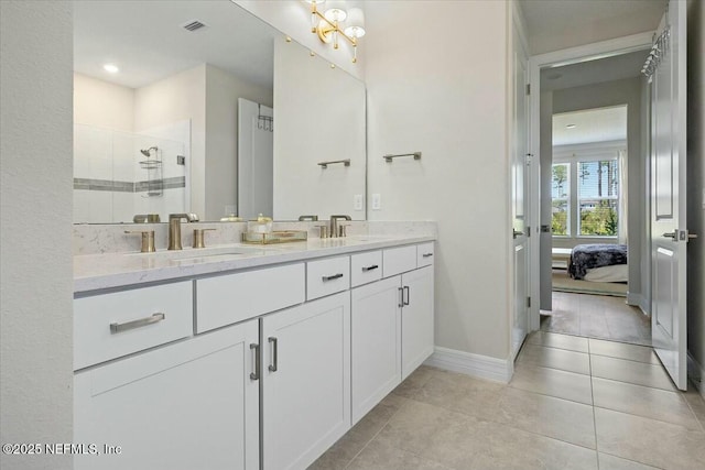 bathroom with a sink, double vanity, visible vents, a stall shower, and baseboards