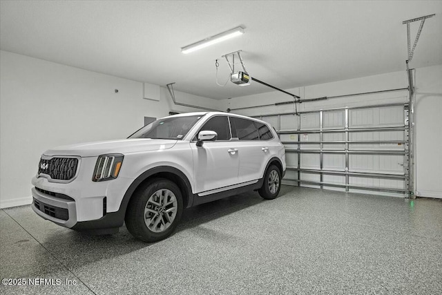 garage with a garage door opener and baseboards