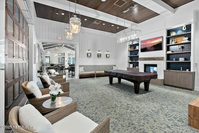 rec room with beamed ceiling, an inviting chandelier, built in shelves, a glass covered fireplace, and visible vents