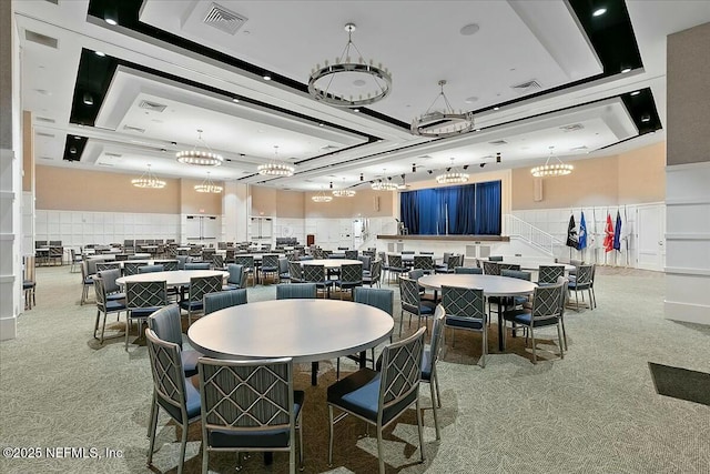carpeted dining area featuring an inviting chandelier and visible vents