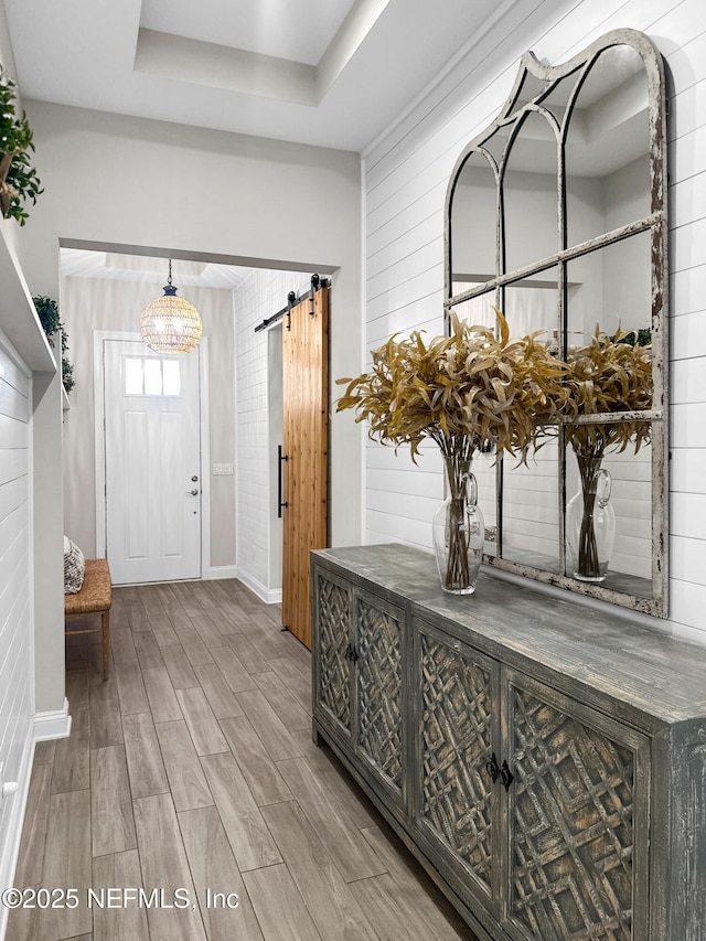 31 Tesoro Ter, Saint Augustine, FL 32095 - entrance foyer featuring baseboards, a tray ceiling, a barn door, and wood finished floors