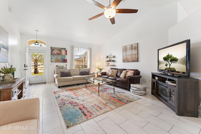 living area with high vaulted ceiling and ceiling fan