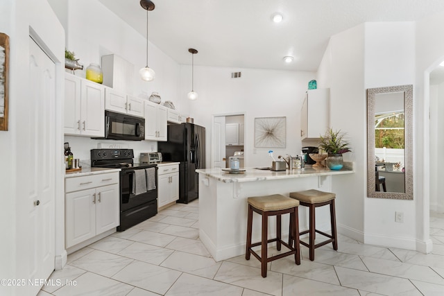 kitchen with black appliances, marble finish floor, a breakfast bar, visible vents, and a peninsula