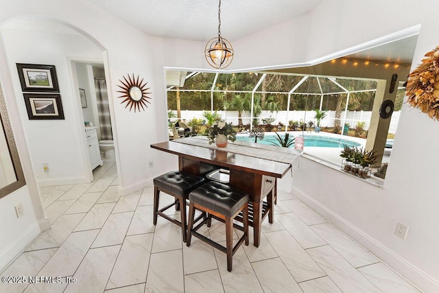 dining space with baseboards, arched walkways, a healthy amount of sunlight, and marble finish floor