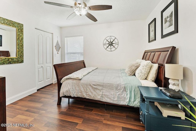 bedroom with a closet, ceiling fan, wood finished floors, and baseboards