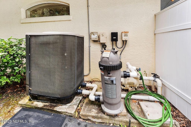 exterior details with central AC, pump, and stucco siding