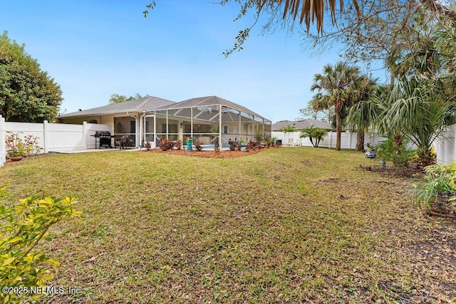 view of yard with a fenced in pool, a patio area, glass enclosure, and a fenced backyard