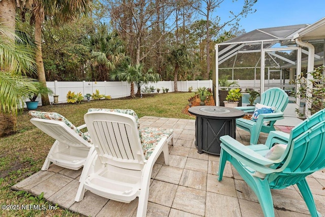 view of patio / terrace with a fire pit, a fenced backyard, and a lanai