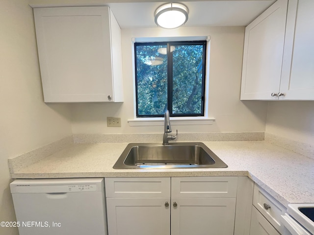 kitchen featuring light countertops, a sink, white cabinetry, and white appliances