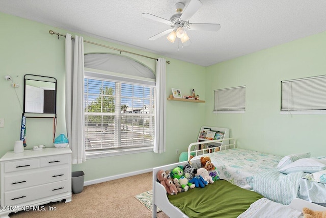 bedroom featuring a textured ceiling, baseboards, ceiling fan, and carpet
