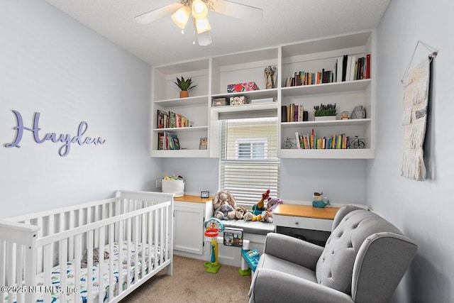 bedroom with ceiling fan, a crib, and light carpet
