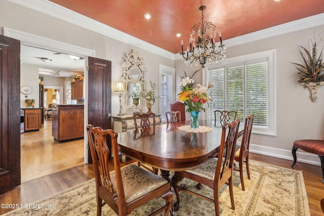 dining space with ornamental molding, light wood-style floors, baseboards, recessed lighting, and a notable chandelier