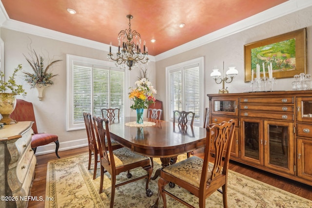 dining space with plenty of natural light, ornamental molding, wood finished floors, and a notable chandelier