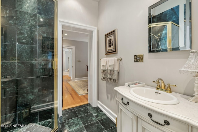 full bathroom featuring baseboards, a shower stall, and vanity