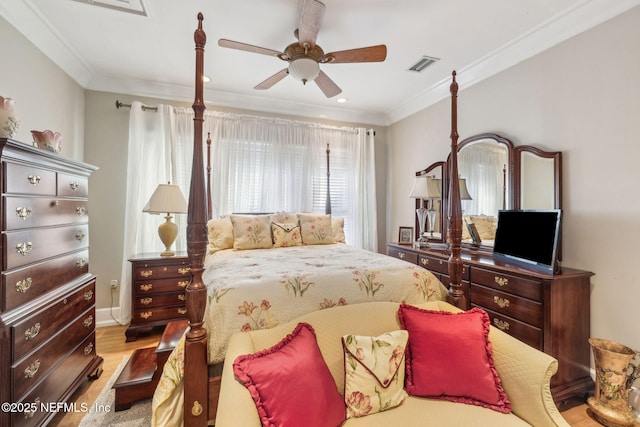 bedroom featuring visible vents, a ceiling fan, crown molding, and wood finished floors