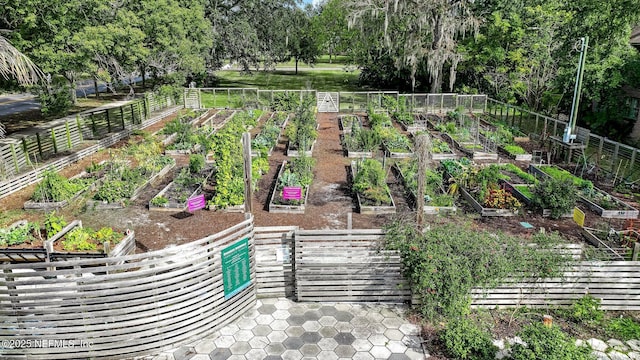 view of community featuring fence and a garden