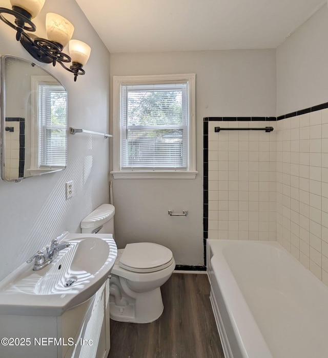 2636 Post St, Jacksonville, FL 32204 - bathroom featuring vanity, a washtub, toilet, walk in shower, and wood finished floors