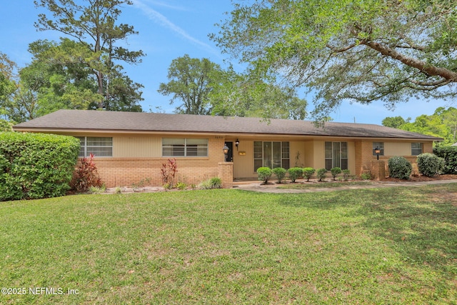 ranch-style house featuring a front lawn and brick siding