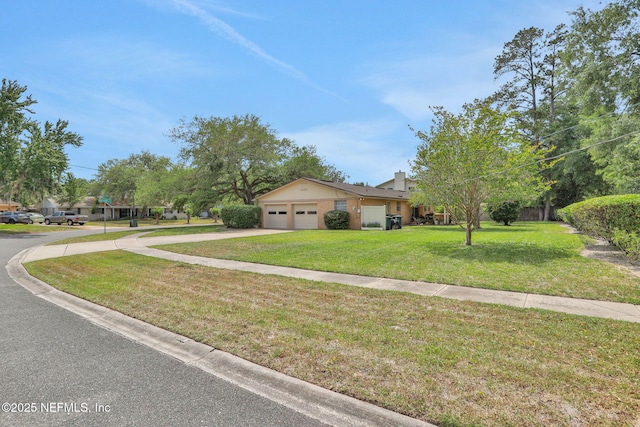 view of front of house with concrete driveway, a front yard, and a garage