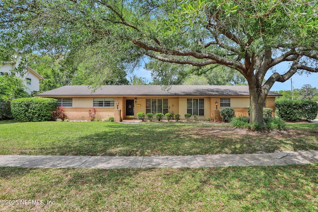 ranch-style house with a front yard and brick siding