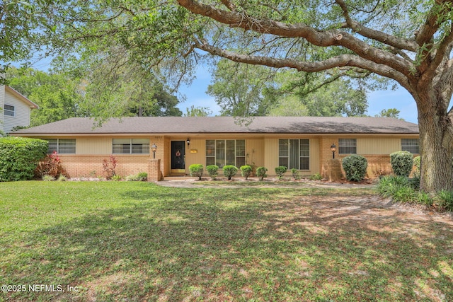 ranch-style house featuring brick siding and a front yard