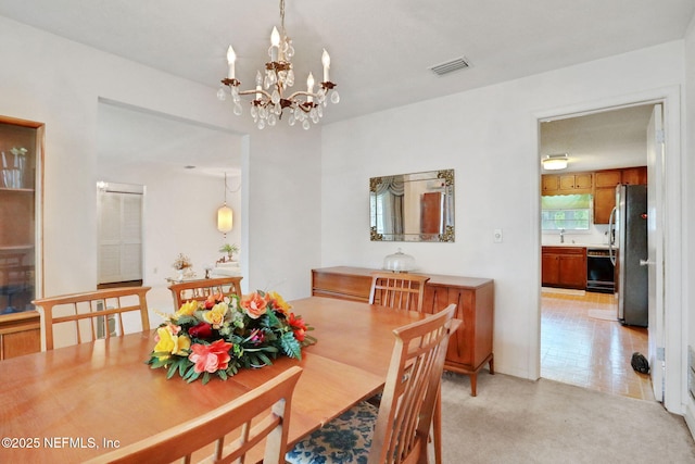 dining space with visible vents and a chandelier