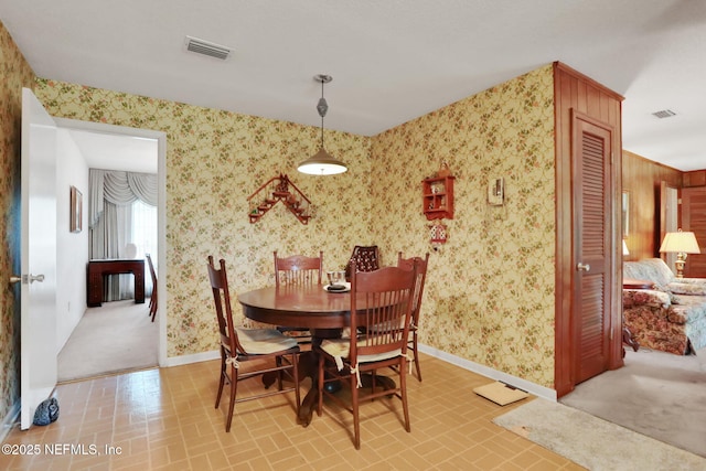 dining room with baseboards, wallpapered walls, brick patterned floor, and visible vents
