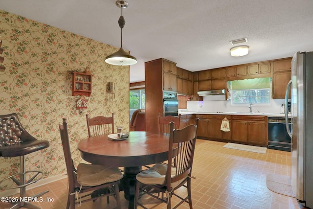 dining room with a wealth of natural light, brick patterned floor, wallpapered walls, and baseboards