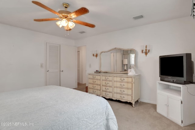bedroom featuring visible vents, a ceiling fan, and light carpet