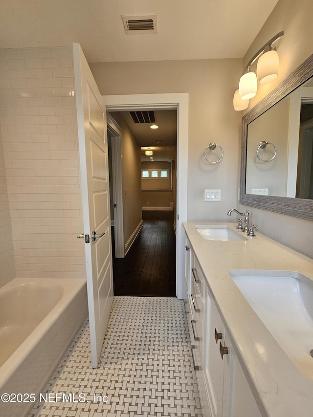 bathroom with a sink, double vanity, and visible vents
