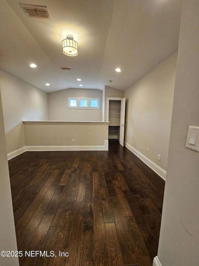 below grade area with baseboards, visible vents, and hardwood / wood-style flooring