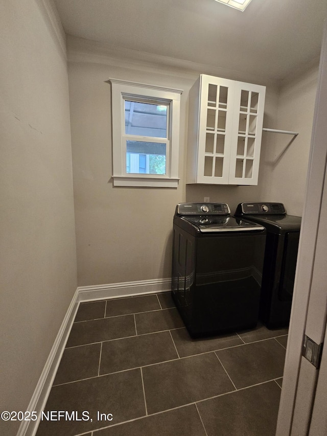 laundry room with laundry area, dark tile patterned floors, baseboards, and washer and dryer