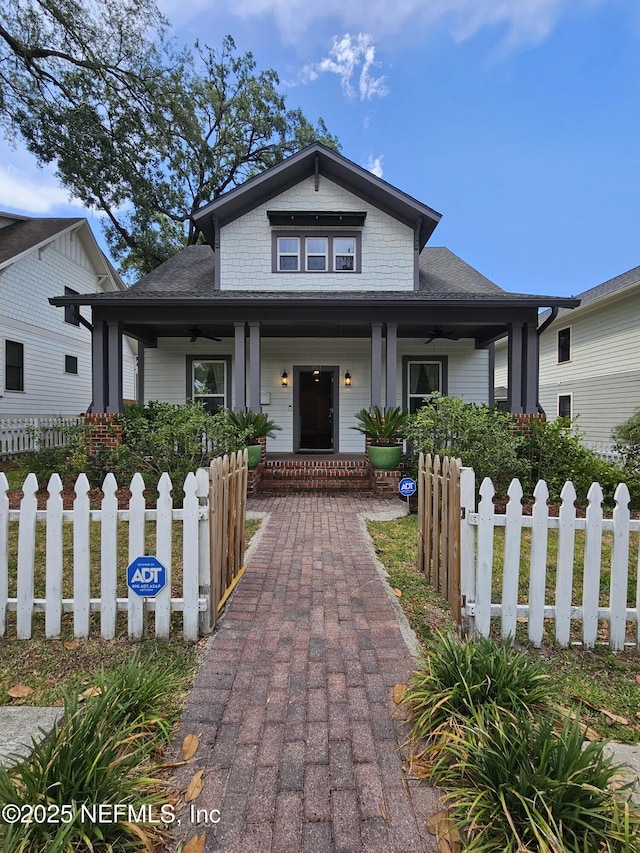 bungalow-style house with a porch, ceiling fan, and a fenced front yard