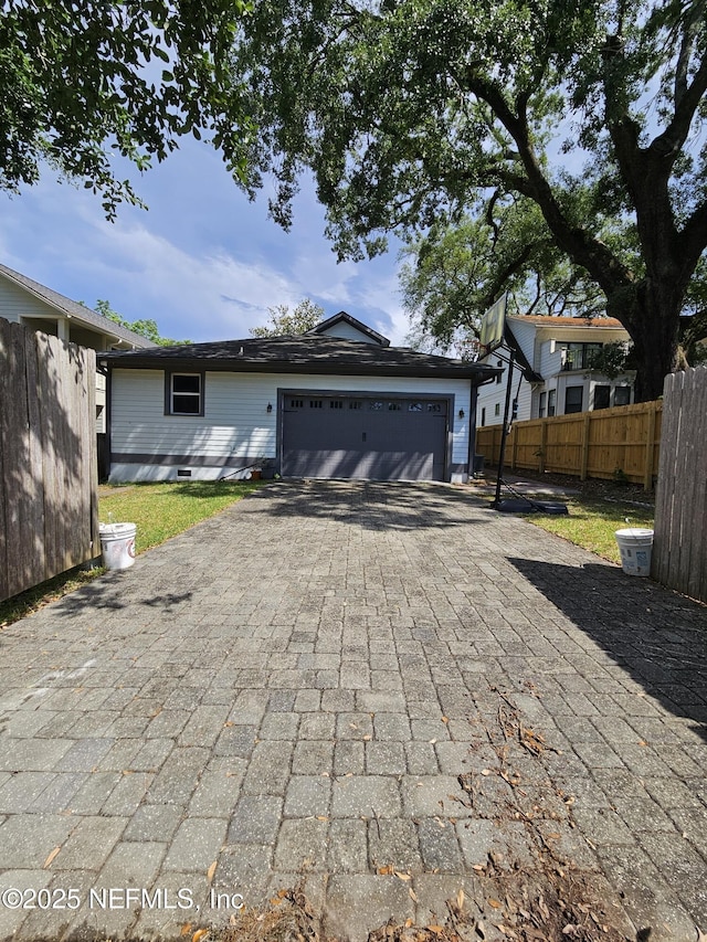view of front of property featuring fence, a garage, and decorative driveway