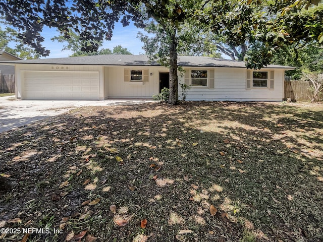 ranch-style home with driveway, a garage, and fence