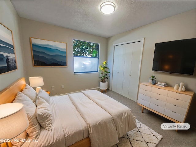 carpeted bedroom featuring a textured ceiling and a closet