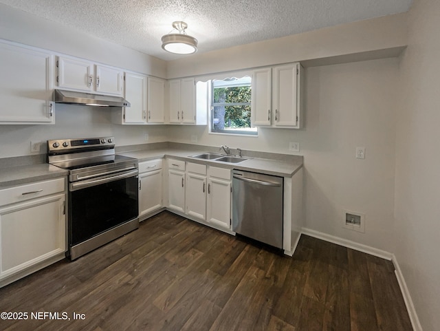 kitchen featuring dark wood-style floors, a sink, stainless steel appliances, under cabinet range hood, and a textured ceiling