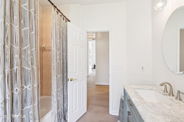 full bath featuring vanity, shower / tub combo with curtain, and baseboards