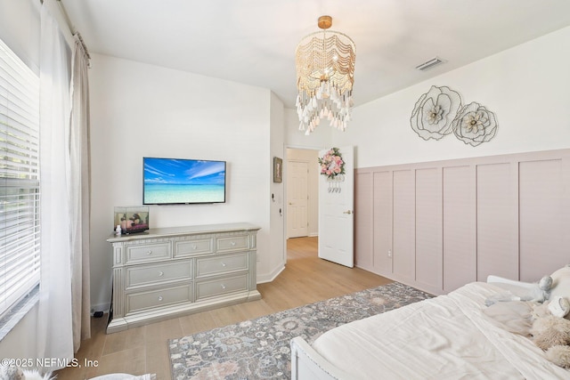 bedroom with a chandelier and light wood finished floors